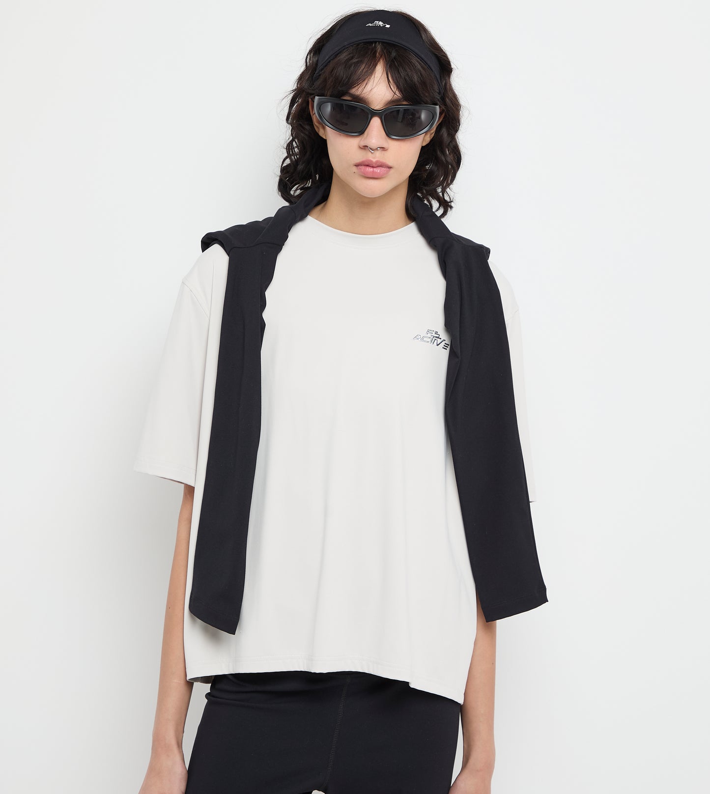 Person wearing a black vest over a white t-shirt on a white background