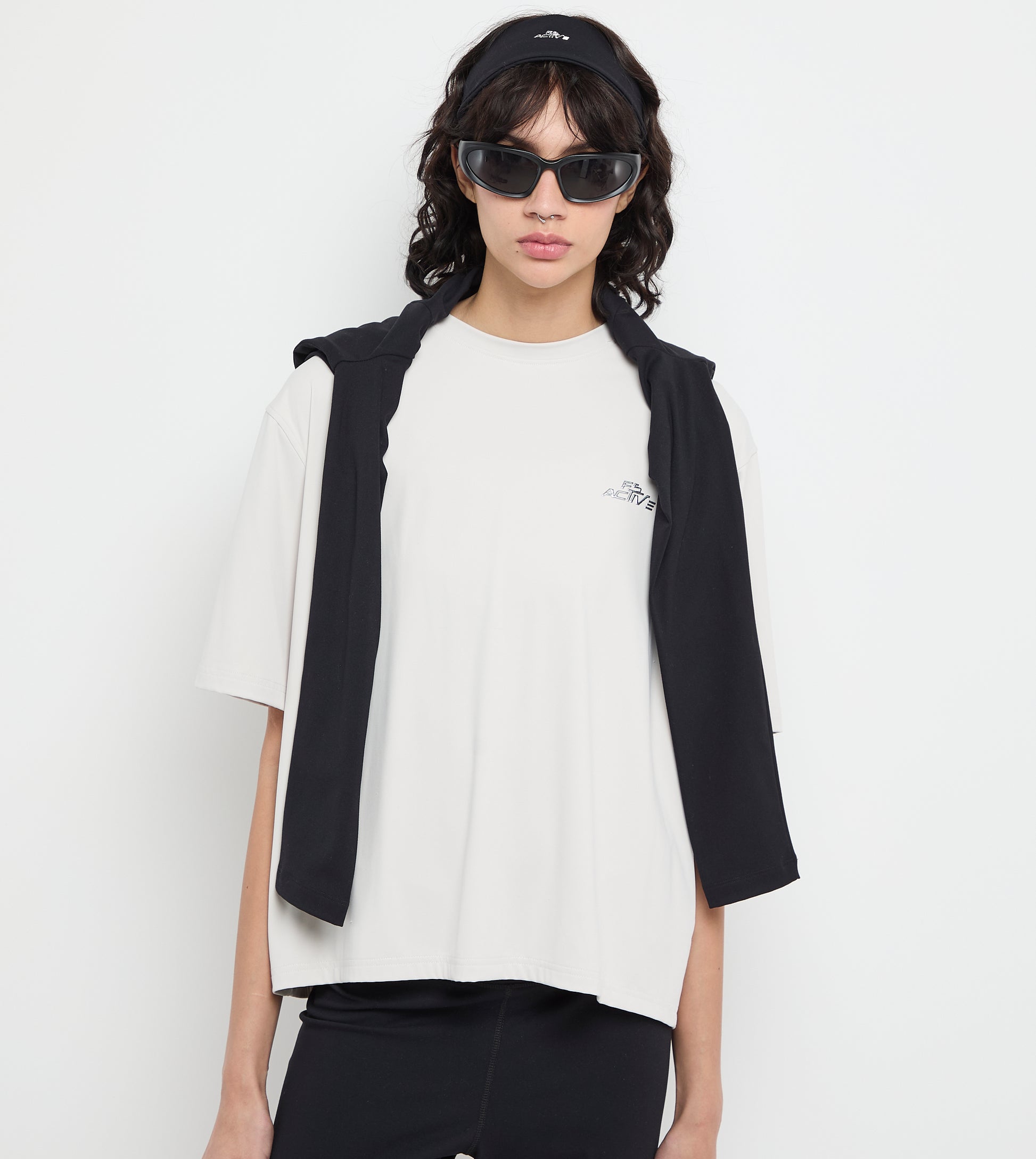 Person wearing a black vest over a white t-shirt on a white background