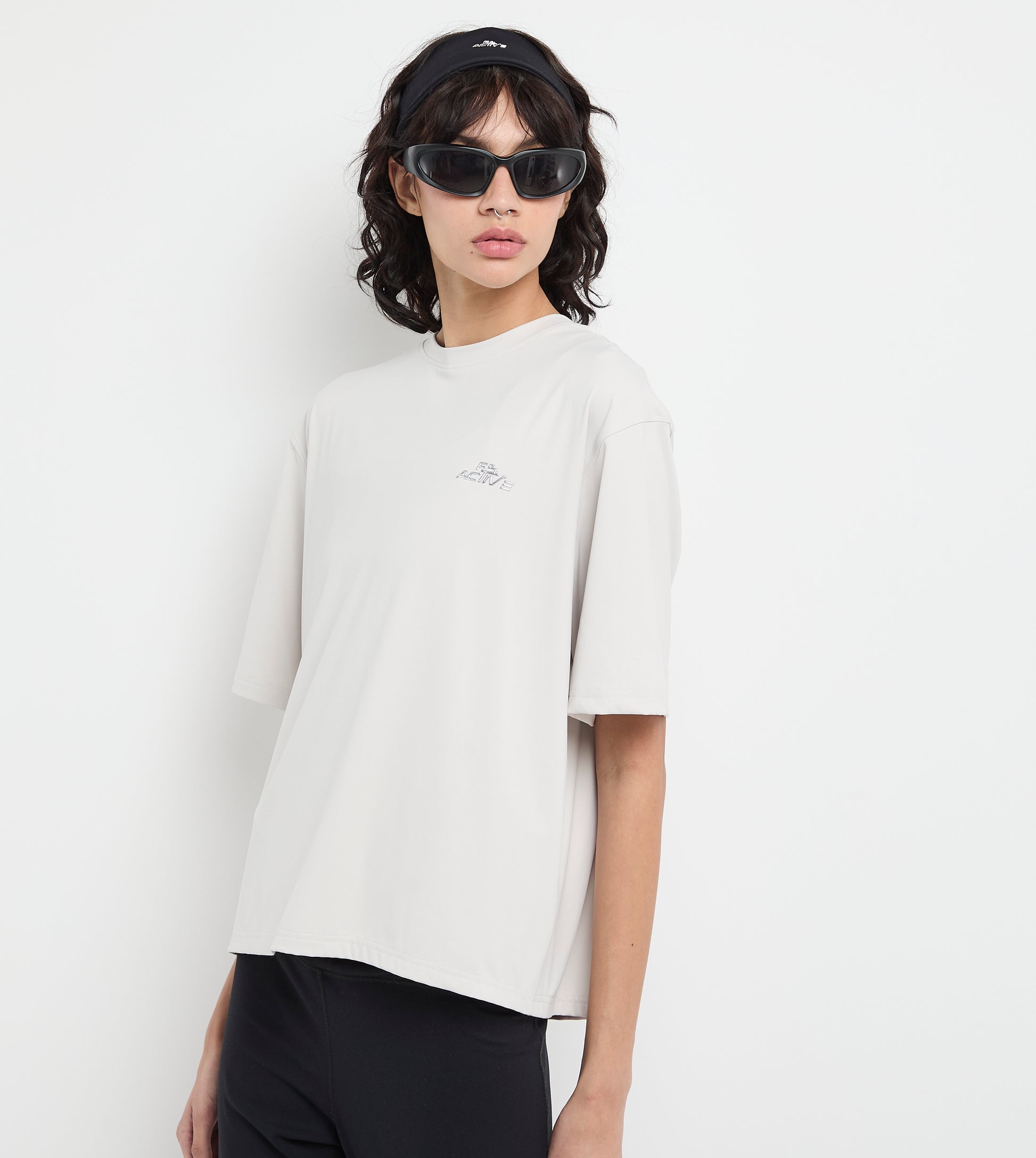 Person wearing a white t-shirt and black pants on a plain background